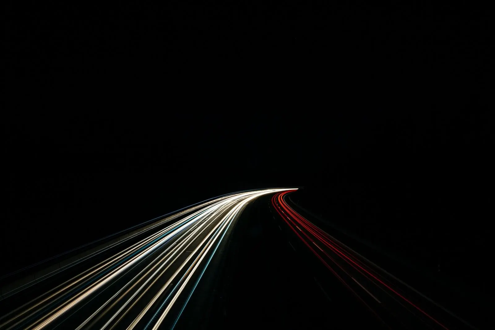 Car light trails on a dark road